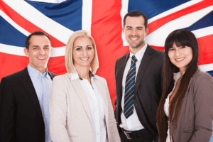 A group of business people standing in front of a British flag, representing professionalism and patriotism.